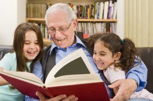 Grandfather reading to girls